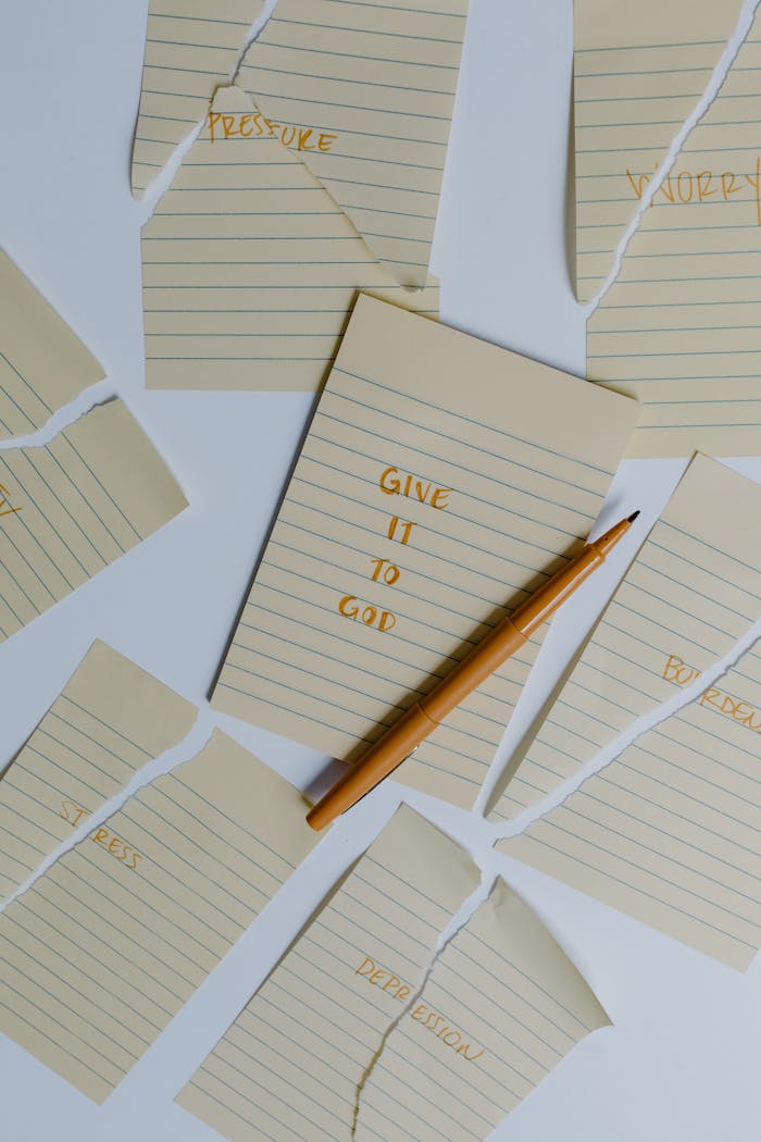 About Flatlay of torn note pages with a motivational quote and pen.